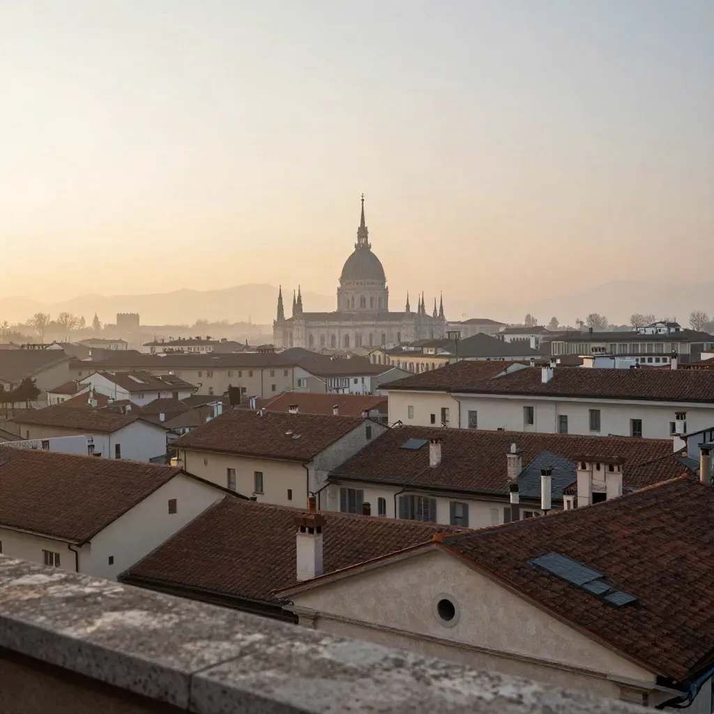 Panorama dell’alba su Milano con il Duomo in alto e tetti sfumati nella nebbia.